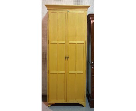 In the manner of Linley; a 20th century beech two door single wardrobe with panelled doors on bracket feet, 92cm wide x 211cm