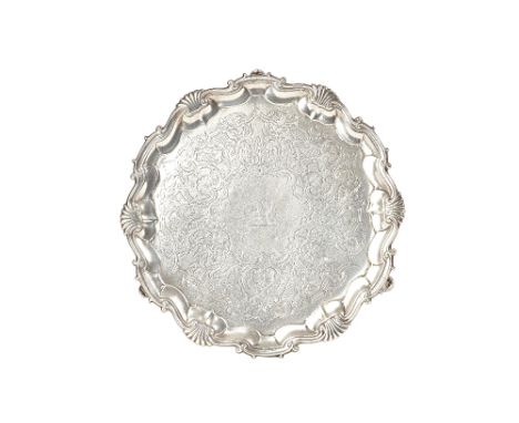 A George II silver salver, of shaped circular form, having a shell and pie-crust rim, with later scroll engraved decoration, 