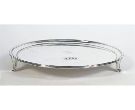 A George III silver salver, of plain circular form, crest engraved to the centre, raised on three tapered feet, London 1790, 
