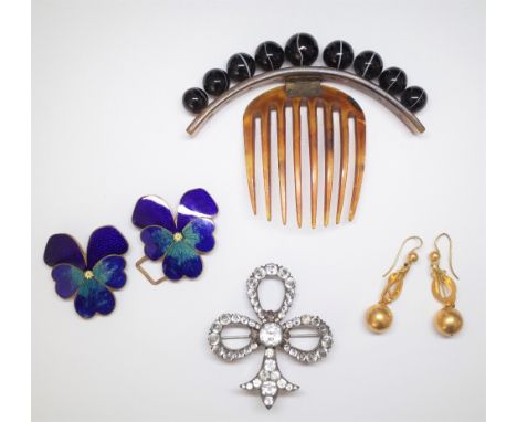 A horn comb mounted with a row of graduated banded agate beads, a gilt metal and enamelled buckle, formed as two pansy flower
