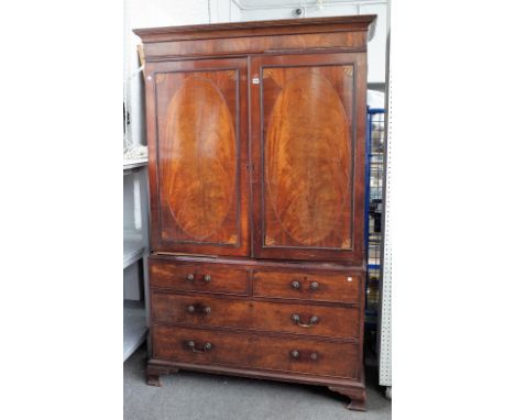 A George III linen press, the pair of inlaid oval panel doors over an associated base, with two short and two long drawers on