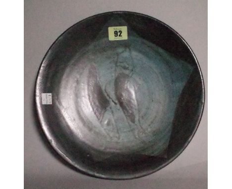 A studio pottery stoneware plate possibly by Bernard Leach, relief decorated with two fish, indistinct seal marks, 27cm diame