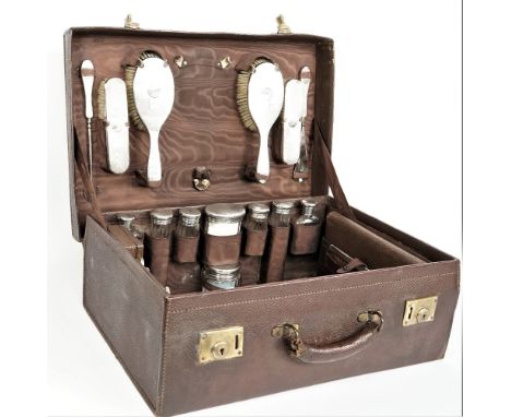 A lady's silver mounted travelling dressing/toilet set, the fittings including; a hand mirror, two hairbrushes, two clothes b