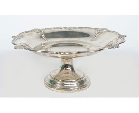 A silver pedestal dish, of shaped circular form, the rim decorated with scallop motifs at intervals, raised on a circular foo