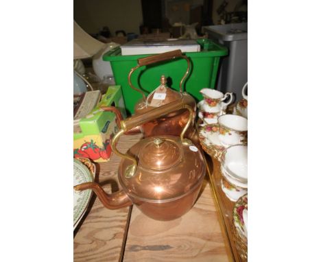 A Victorian copper kettle with an acorn finial and a second Victorian copper kettle with a brass button finial. (2)