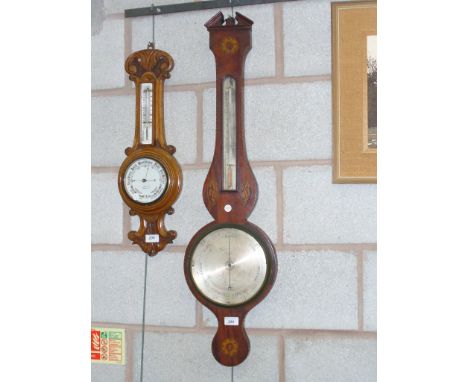 A George III mahogany wheel barometer the thermometer flanked by two oval inlaid conch shells above a silvered dial.