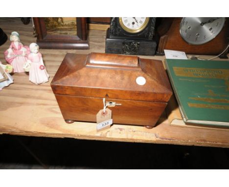 A 19th Century sarcophagus shaped mahogany tea caddy with a twin compartment interior and raised on bun feet.