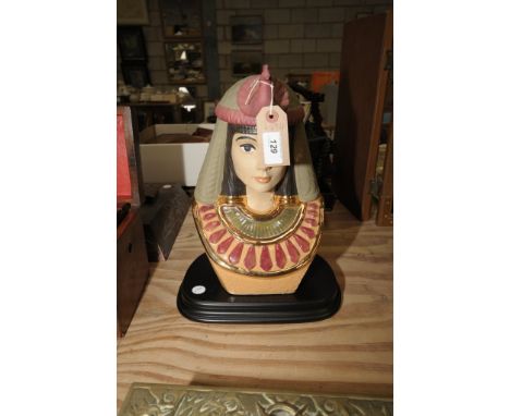 A Ceramic bust of an Egyptian on a hardwood plinth.