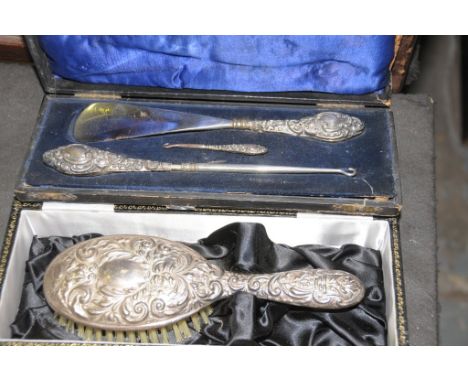 A Cased Victorian silver handled shore horn and two silver handle button hooks and a cased Victorian silver backed hair brush