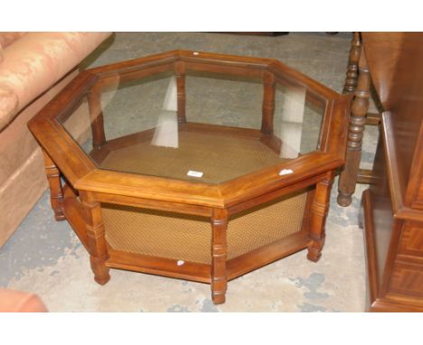 A Modern hardwood glass top octagonal coffee table with a rattan under shelf.