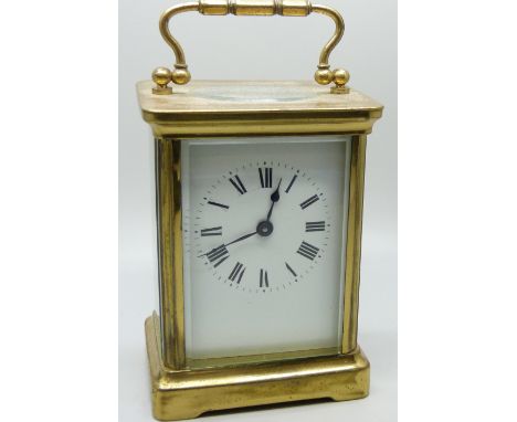 A brass carriage clock with carry handle and key, 11cm