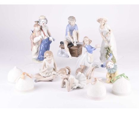 A group of Nao figures and four Lladro bisque bells, including two ballerinas, two clown figures, plus one Nadal figure of a 