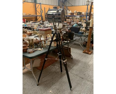 A STANDARD LAMP IN THE FORM OF A SEARCH LIGHT ON A BLACK WOODEN TRIPOD STAND 