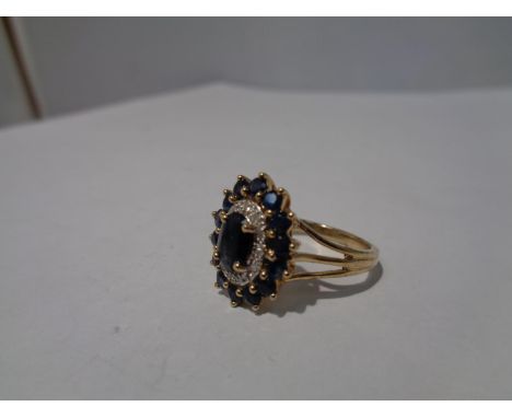 A 9 CARAT GOLD CLUSTER RING WITH A CENTRE SAPPHIRE AND SURROUNDING DIAMONDS AND SAPPHIRES SIZE 0 