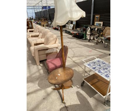AN OVAL WALNUT MODERN OCCASIONAL TABLE ON TRIPOD BASE AND 1970'S STANDARD LAMP COMPLETE WITH SHADE 