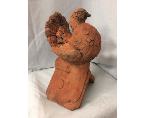 A TERRACOTTA ROOF TILE FINIAL OF A DOVE 