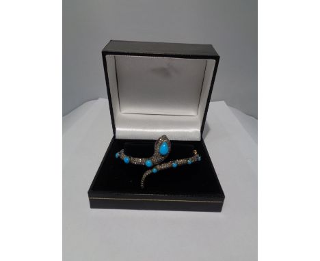 A GOLD AND WHITE GOLD SNAKE BANGLE ENCRUSTED WITH DIAMONDS, RUBY EYES AND BLUE NAJAVO STONES 
