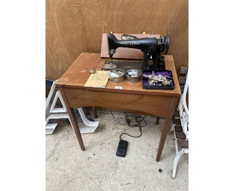 A SEWING TABLE ENCLOSING A VINTAGE SINGER SEWING MACHINE COMPLETE WITH SINGER WORK LAMP AND VINTAGE SINGER SEWING CASE AND FO