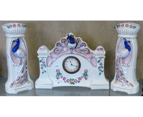 A Belgium clock garniture in white ceramic with peacock emblems