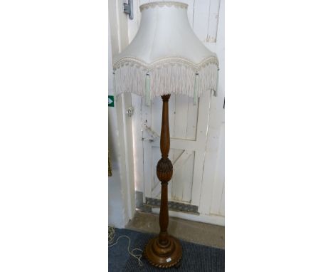 An oak standard lamp with cream and pink frilled shade