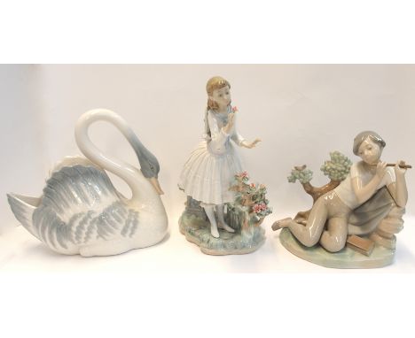 A Nao swan centrepiece, a Lladro boy playing a pipe (def) and a girl smelling a flower (def) Condition Report: Available upon