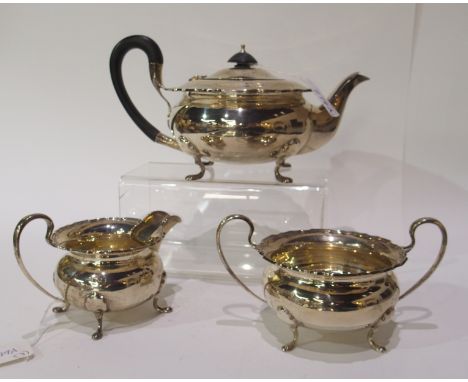 A three piece silver tea service by Walker &amp; Hall, Sheffield 1935 of squat bulbous form with scalloped border on four out