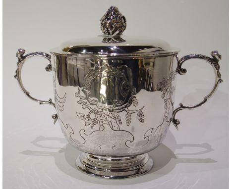 A twin handled silver pot and cover by Skinner &amp; Company, London 1906, the body with fruit and vine decoration, blank car