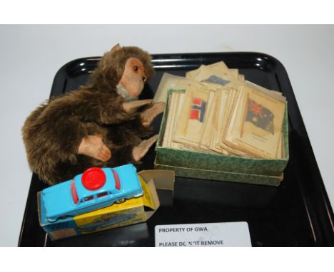 A collection of Kensitas silk cigarette cards of British Empire flags, Monkey soft toys, lacking stuffing and Corgi 236 model