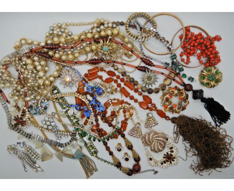 A collection of vintage costume jewellery to include brooches, strings of beads, slave bangles etc Condition Report: Availabl