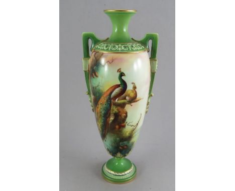 A Royal Worcester porcelain hand-painted tall two-handled vase, c. 1900. It is decorated with peacocks to one side and pine c