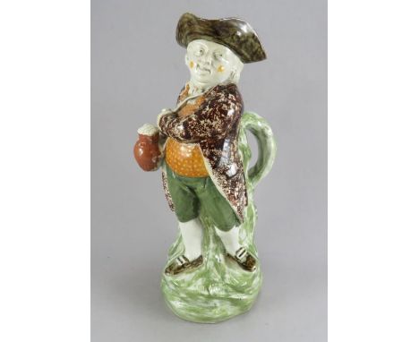 An early nineteenth century pearlware Hearty Good Fellow toby jug, c. 1800. It is decorated in greens, magenta and orange. 30