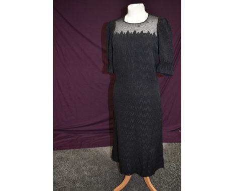 A late 1930s black dress having textured zig-zag pattern with robust tulle like yolk and cuff detail, back self covered butto