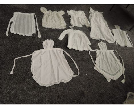 A selection of vintage and antique children's clothing including aprons and dresses, some nice details to many pieces.