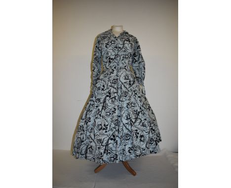 A 1950s cotton day dress having black rose print over blue stripes, larger size.