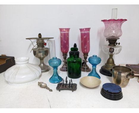 A mixed lot to include a Duplex brass  oil lamp with cut glass reservoir and cranberry shade, a pair of silver plated storm l