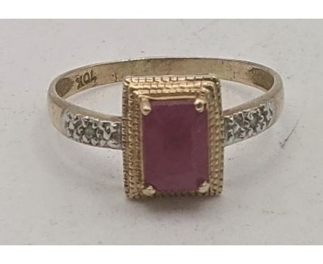 A yellow gold ring stamped 10K having an emerald cut ruby in four-claw setting flanked by two small diamonds, size P 1/2, 1.6