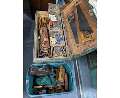 A large wooden green painted tool chest with fitted interior with various woodworking tools to include chisels, saws and othe