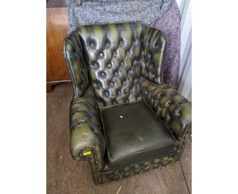 A late 20th century green leather button upholstered Chesterfield style wing back armchair and a George III mahogany D end di