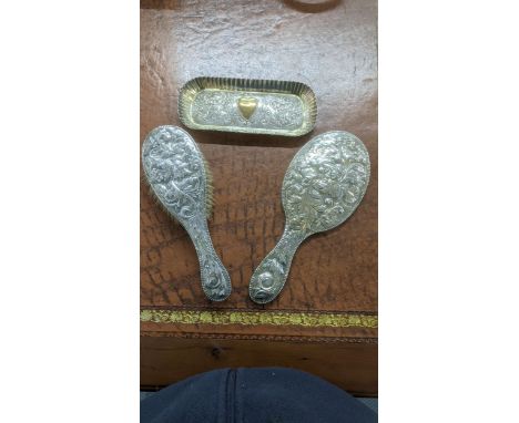 Silver dressing table items to include a rectangular form with embossed decoration depicting a central gilt heart flanked by 