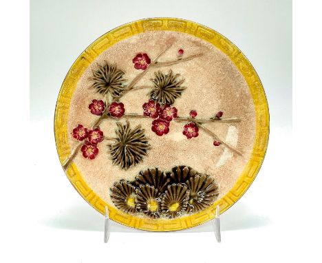 Ceramic plate with beige background, yellow Greek key impressed border pattern, and blossoming tree branches.Wedgwood impress