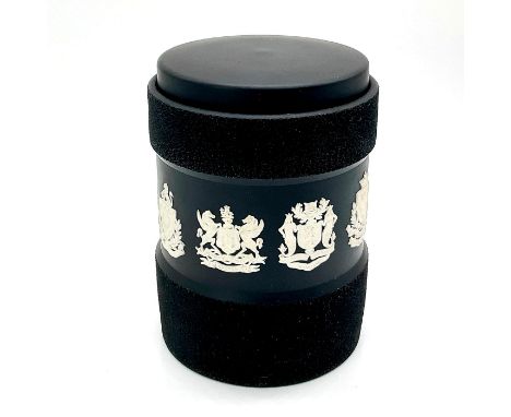 Black jasperware lidded tea caddy with crests encircling body in white relief.Wedgwood backstamp. Issued: 20th c.Dimensions: 