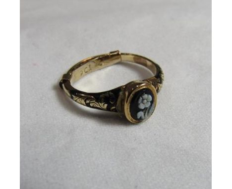 A Victorian unmarked gold (tested) mourning ring with a small black lacquered signet panel with white floral detail and black
