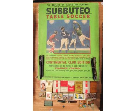 A Subbuteo table soccer set which includes seven different teams together with a small quantity of various teacards in cigare