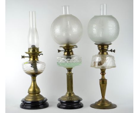 Three brass oil lamps with glass reservoirs, shades & flus, including Hinks & Lamp WorksHinks has internal hairlines to glass