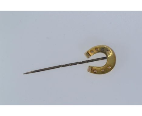 Yellow metal horseshoe stick pin, with steel pin, yellow metal tests positive for 18ct gold, gross weight 2.79 grams, losses 