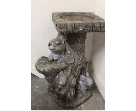 A TREE TRUNK DESIGN BIRDBATH WITH RABBIT FIGURES