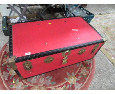A LARGE RED STUDDED PACKING TRUNK 