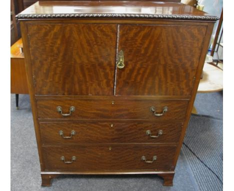 A reproduction mahogany drinks cabinet, galleried top, dragooned border, two door cupboard over three graduated drawers, swin