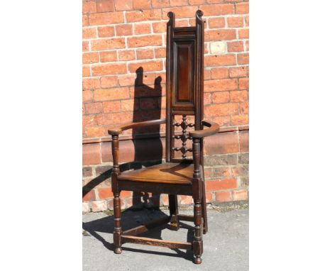 An Arts & Crafts oak hall chairPossibly Scottish, having carved bent side arms, with bobbin form back support, raised on bun 