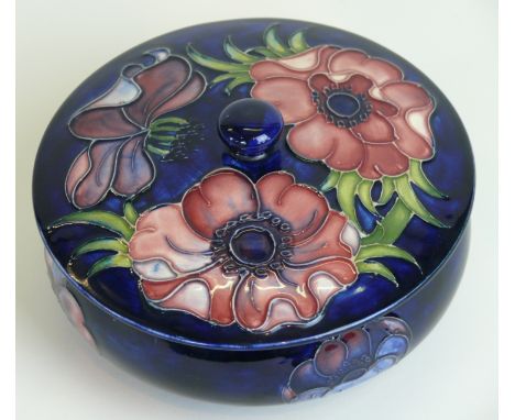 A Walter Moorcroft pottery circular trinket bowl and coverDecorated in the Anemone pattern on a blue ground, impressed marks 